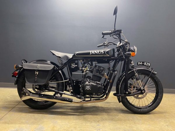 Black Janus Halcyon 250 motorcycle parked indoors with saddlebag.