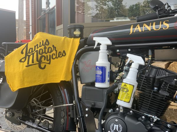 Janus motorcycle with branded towel and cleaning supplies on display.