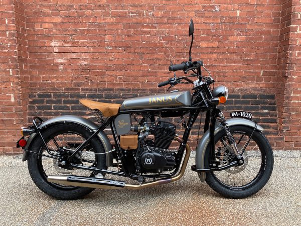 Vintage-style motorcycle parked against a red brick wall.